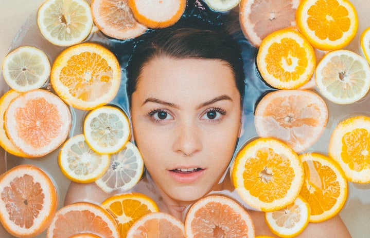 woman surrounded by lemons and oranges