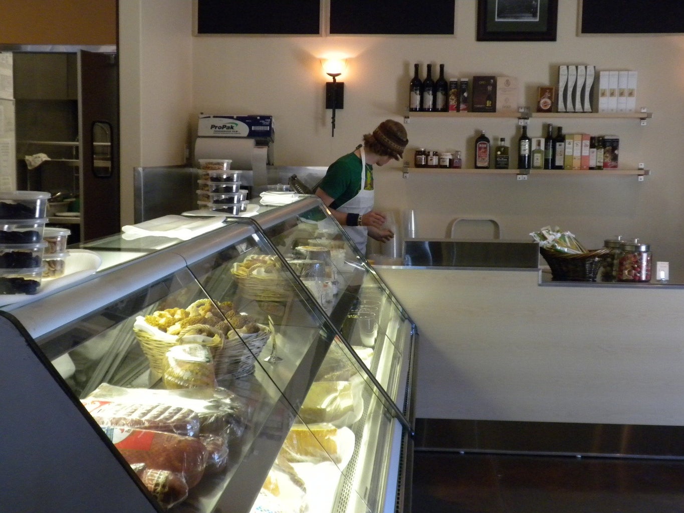 a bakery counter in a grocery store. a man stands behind it, facing away from the camera.