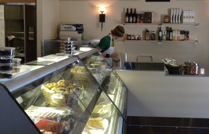 a bakery counter in a grocery store. a man stands behind it, facing away from the camera.