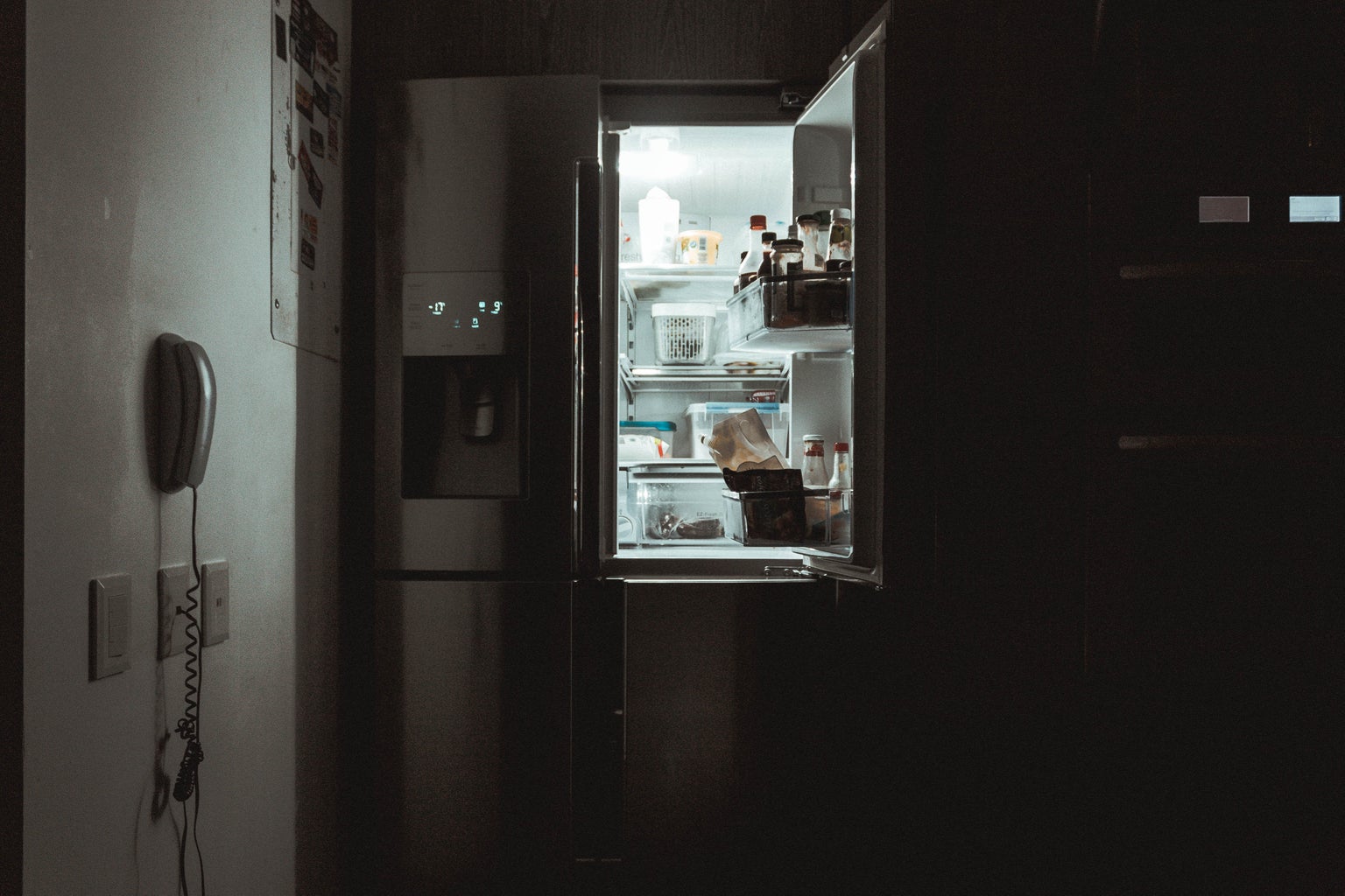 an open fridge door in the darkness