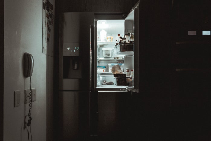 an open fridge door in the darkness
