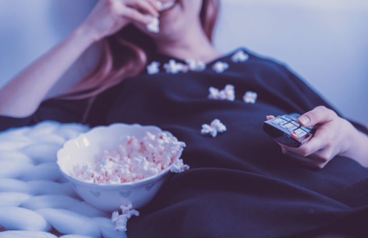 woman watching a movie eating popcorn