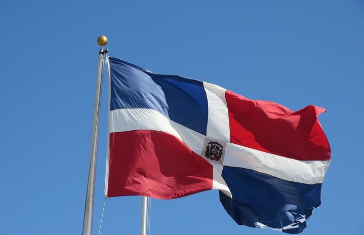 Dominican flag in front of blue sky