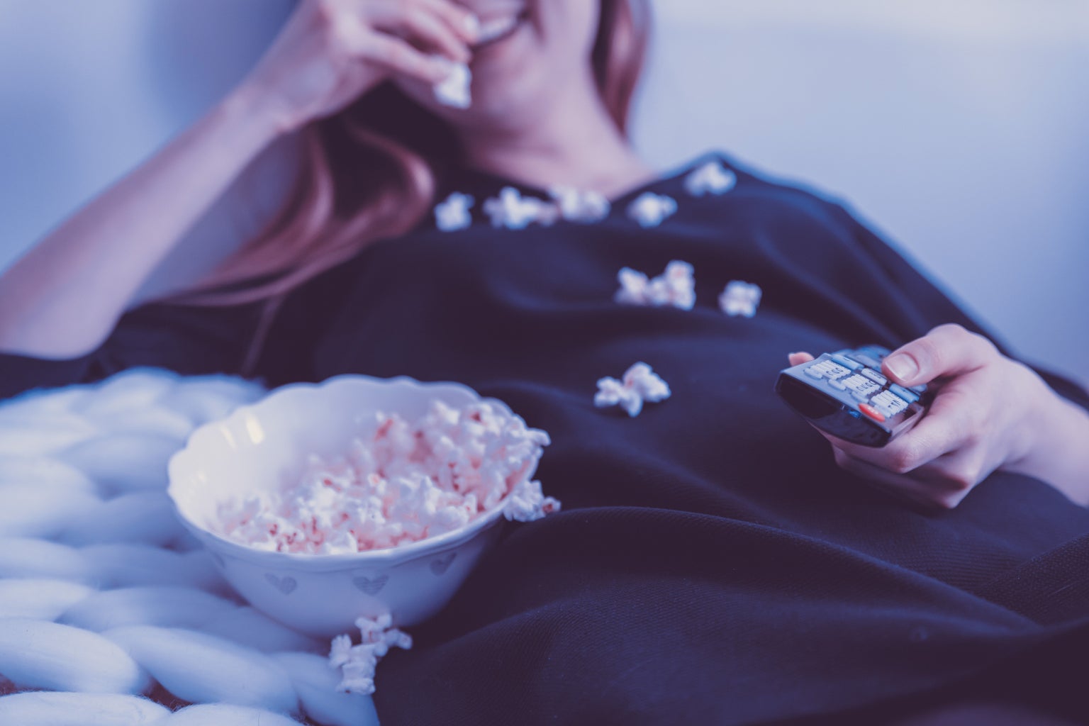 woman lying down eating popcorn
