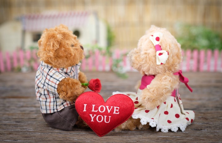 two teddy bears with a heart that says \"i love you\" between them