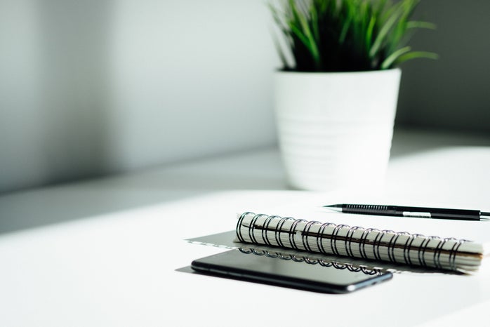 Pen, notebook and phone on work desk