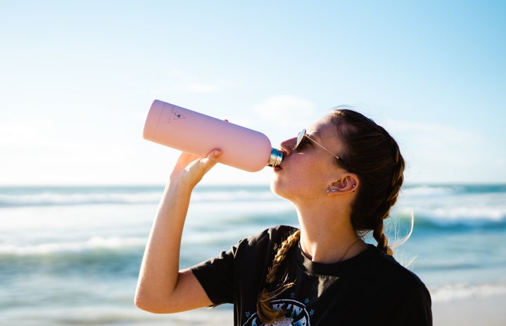 drinking from water bottle on beach