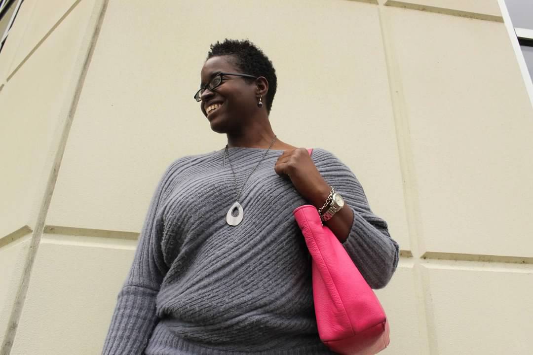 Kisha Rahming smiling with a pink purse on her arm