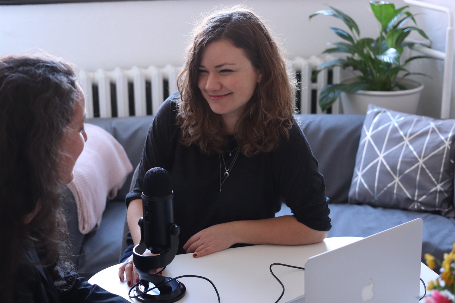 Girl in front of a microphone with a friend