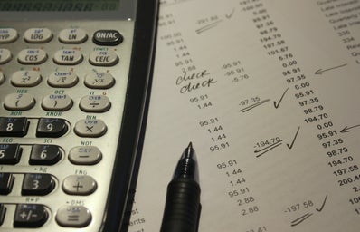 a calculator covers a spreadsheet of expenses