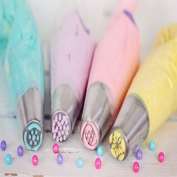 Different colored icing bags with different piping tips on the ends