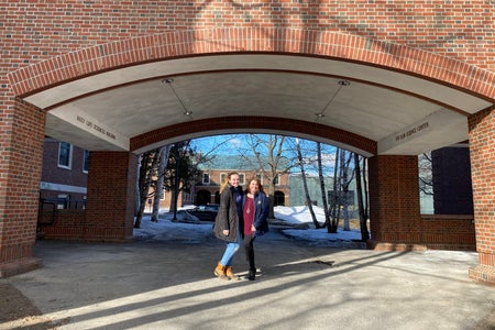 mom and daughter standing under building
