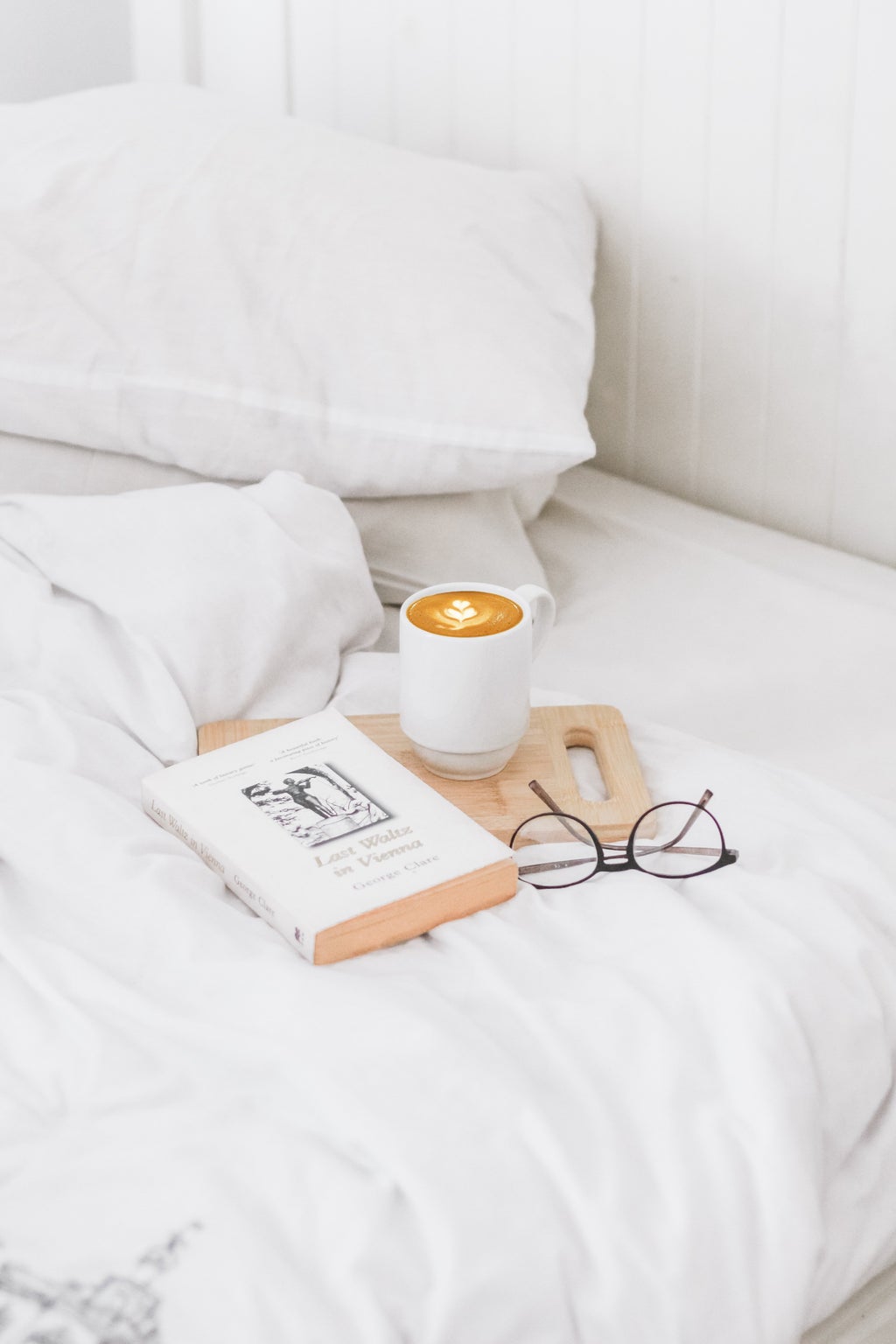 a bed with some books and a coffee