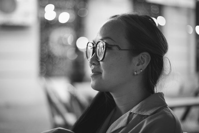 Black and white photo of an Asian woman with a black-framed eyeglasses