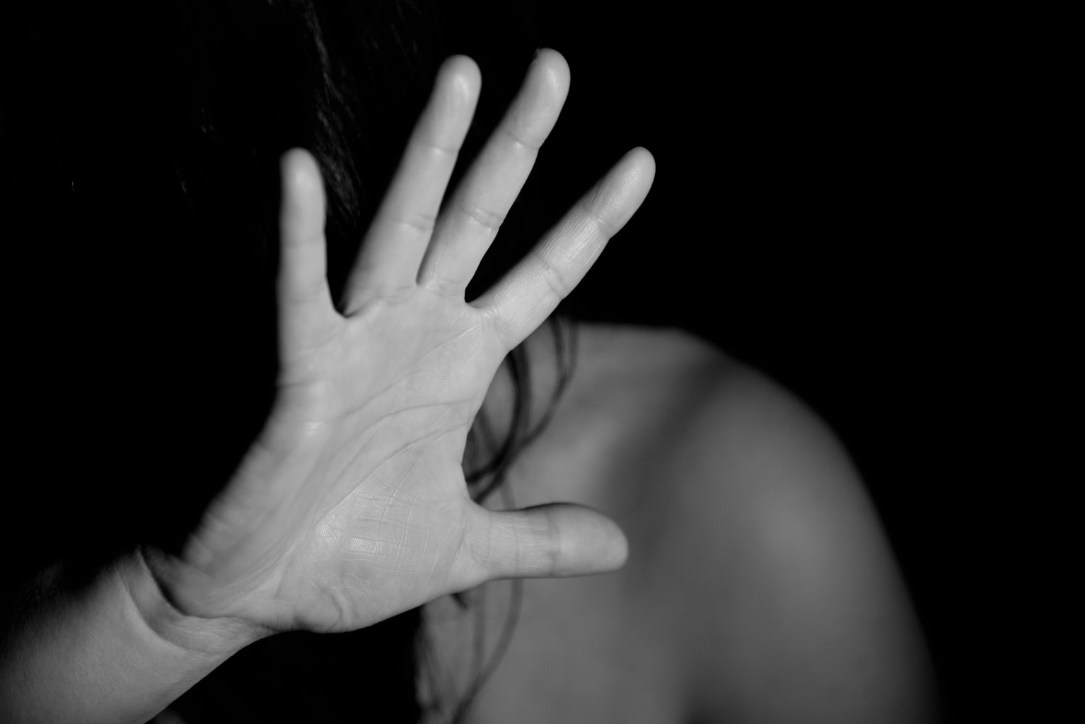 woman with her hand up to cover her face