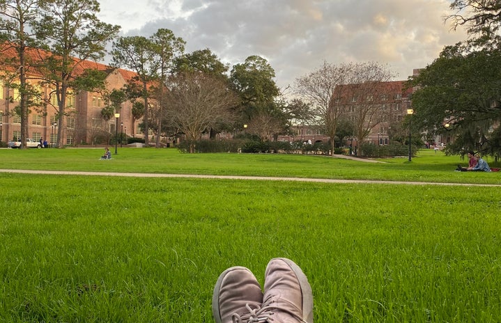 I am laying on Landis Green with pink shoes