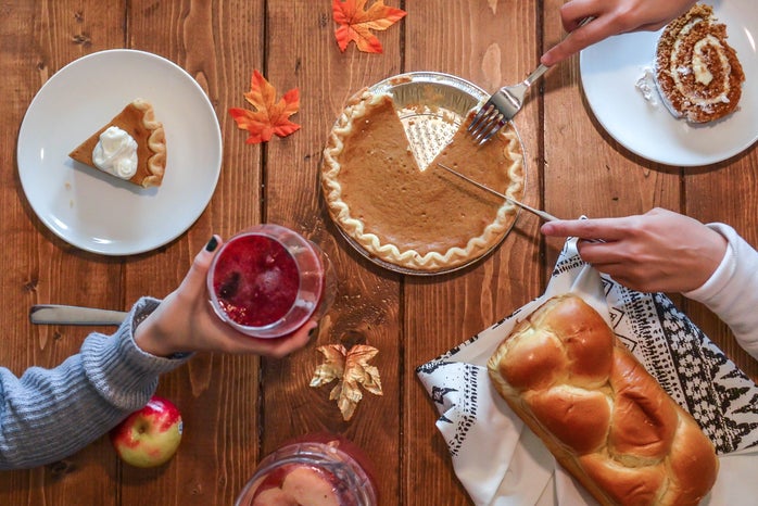 wooden dinner table with pie, bread, and cake