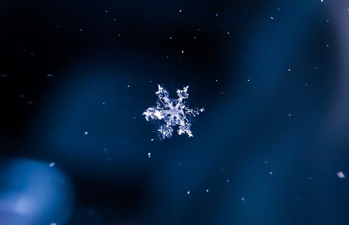 a design of a snowflake against a dark blue background