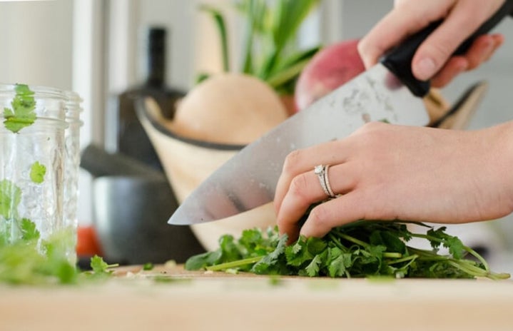 Hands chopping cilantro