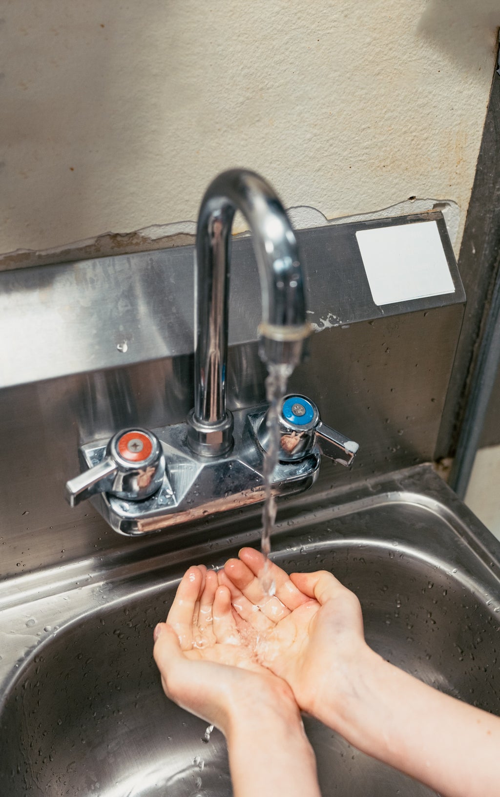 person watching hands at sink