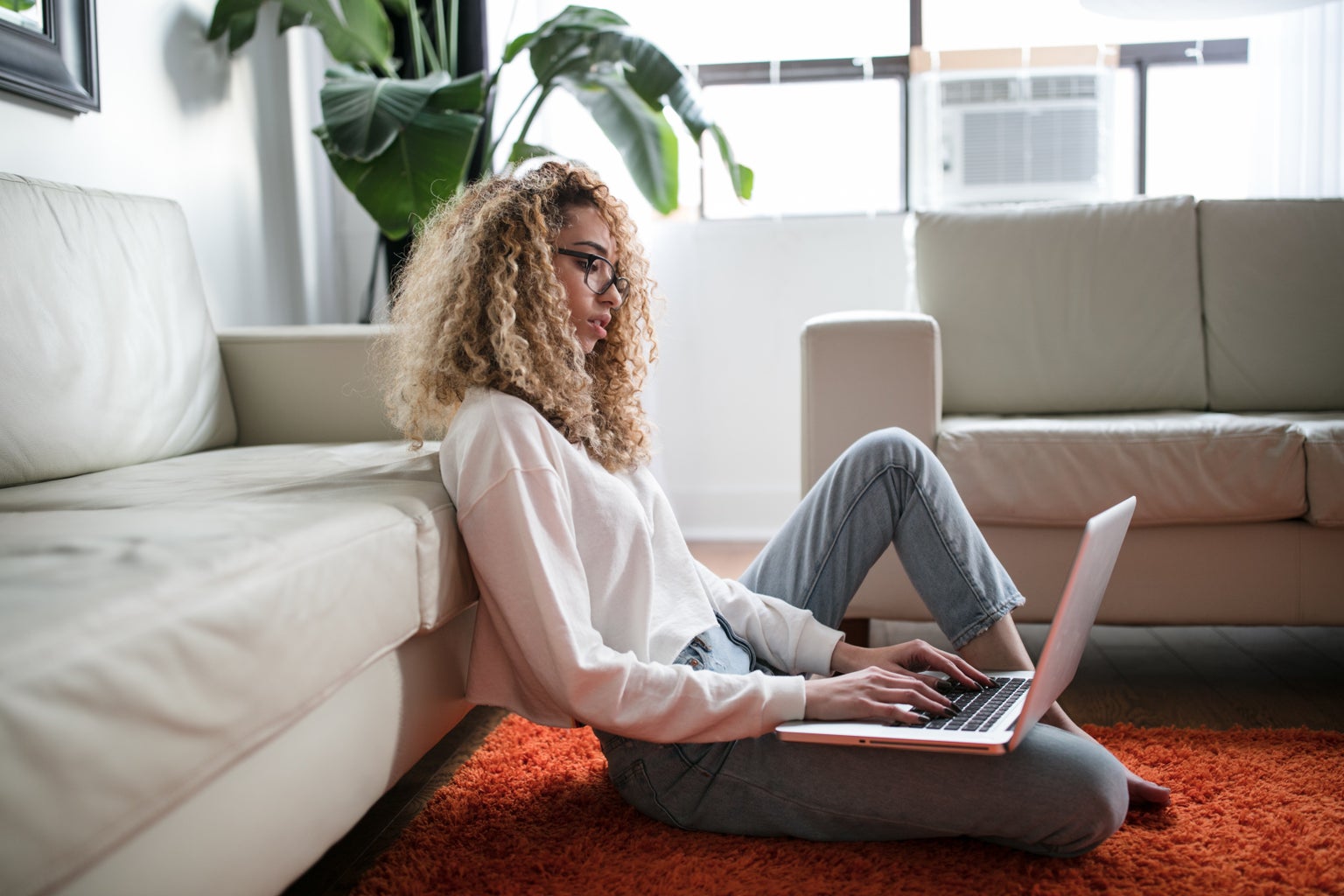 woman sitting on floor with laptop working from home