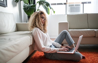 woman sitting on floor with laptop working from home