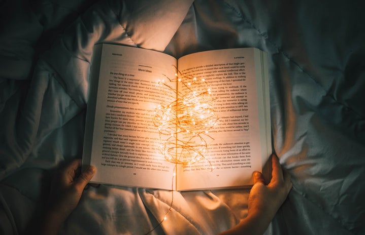 Person holds string lights inside of book