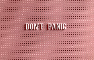Don\'t Panic sign with pink backdrop