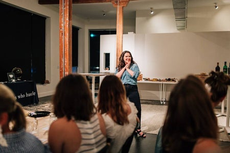 woman standing in front of group of people, hands together
