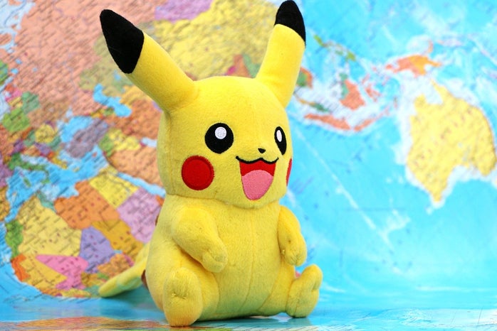 Pikachu (Pokemon) stuffed animal with world map background