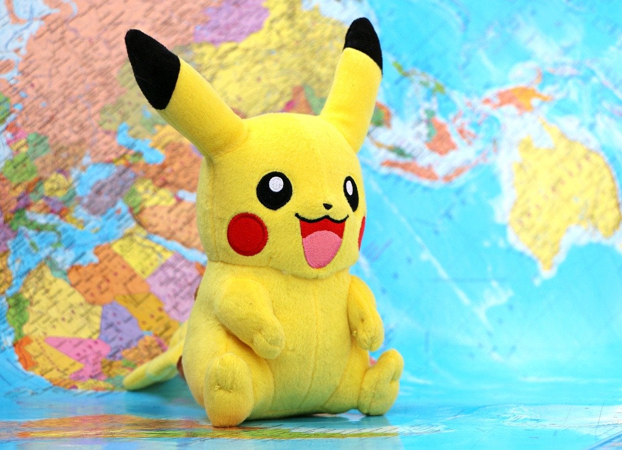 Pikachu (Pokemon) stuffed animal with world map background