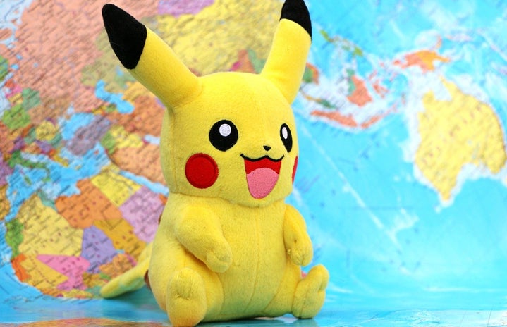 Pikachu (Pokemon) stuffed animal with world map background