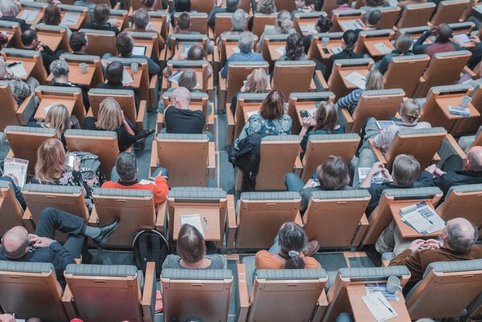 high-angle photo of people seated in a lecture hall