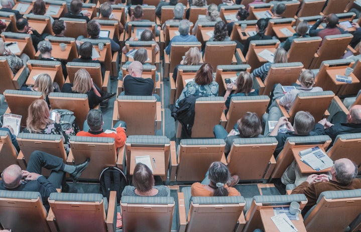 high-angle photo of people seated in a lecture hall