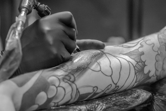 grayscale photo of person applying tattoo 955938jpg?width=698&height=466&fit=crop&auto=webp