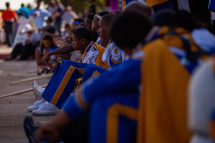 high school marching band sitting on ground