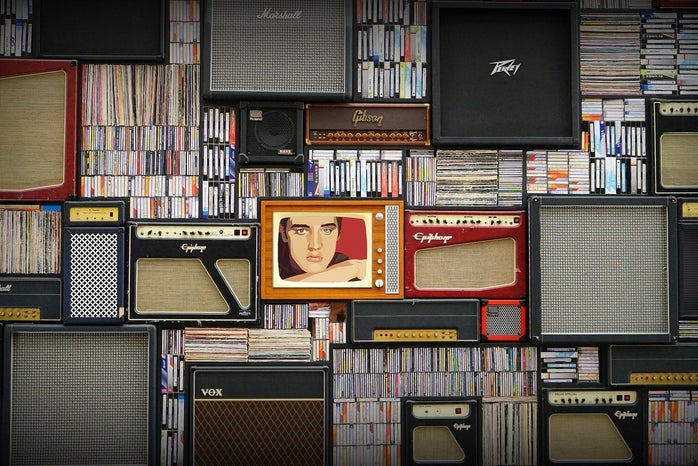 Various speakers and musical records. Image of Elvis Presley centered.