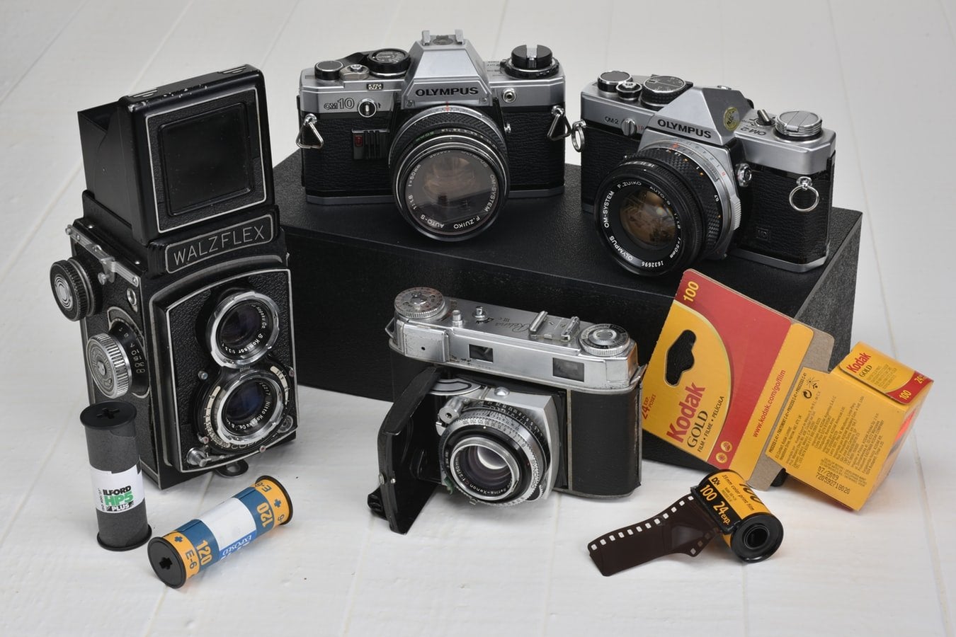 various films cameras and rolls of film stock against white background
