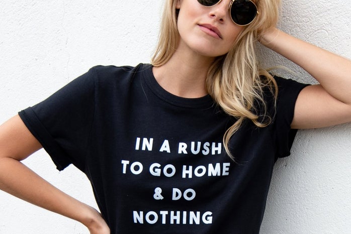 woman modeling t-shirts from lulusimonstudio\' that says \"in a rush to go home and do nothing\"