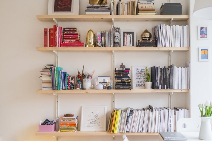 floating wooden shelves full of books, art prints and other knickknacks