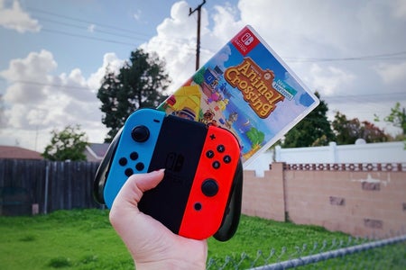 animal crossing game and Nintendo switch controller being held up