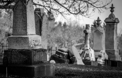 grayscale photo of tombstones in a graveyard