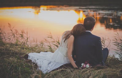 Bride and Groom sitting near a lake