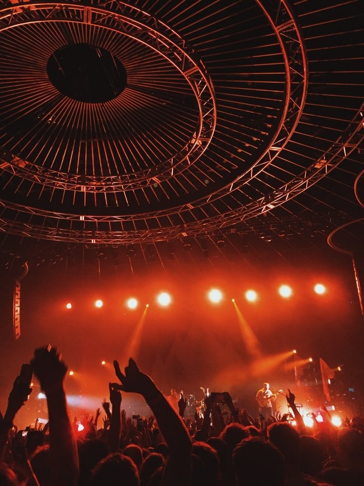 A huge concert crowd, all colored red by the lights