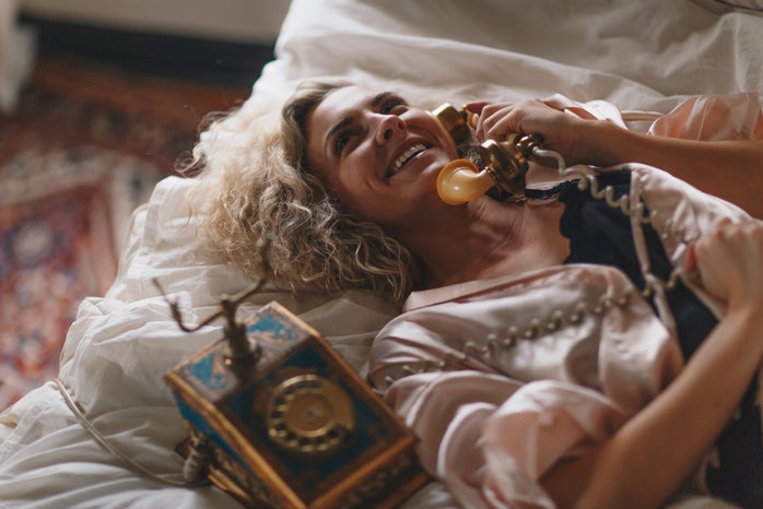 woman on bed making a phone call
