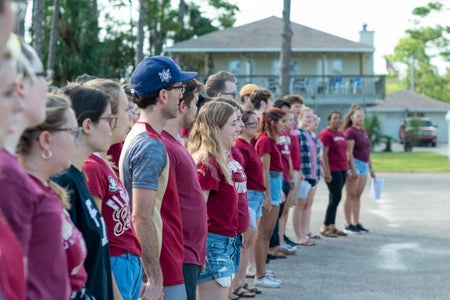 People in garner shirts holding hands