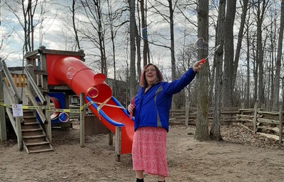 Image of Katrina making bubbles at a park