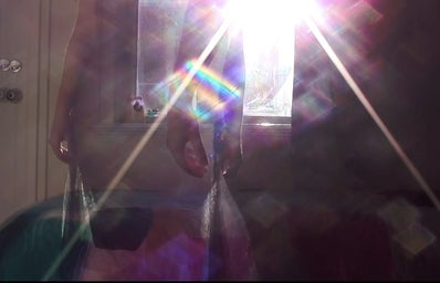 Screenshot from my own film, silhouettes of woman in the light with rainbow image.