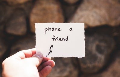 person holding piece of paper with phone a friend written text, mental health