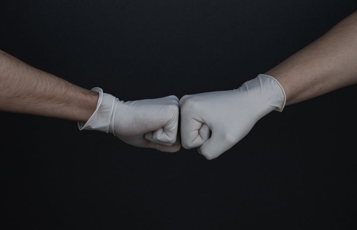 hands with gloves on fist bumping